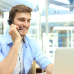 Happy young male customer support executive working in office